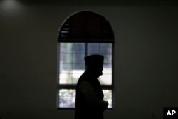 FILE - An imam prays at a mosque in Chino, California, Nov. 18, 2016. Targeting clerics opposed to the Islamic State in a new propaganda campaign, the jihadist group is thought to have launched an effort aimed at deligitimizing them, especially in the eyes of young Muslims.
