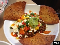 A breakfast of Chorizo sausage, black beans, rice, goat cheese, eggs, guacamole, salsa roja with multi-grain tortillas. (Photo: Julia Taboh / VOA)