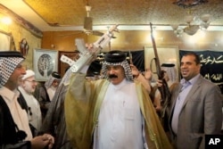 FILE - Iraqi Shiite tribal leaders chant slogans against the al-Qaida-inspired Islamic State of Iraq and the Levant in Baghdad, Iraq, June. 13, 2014.