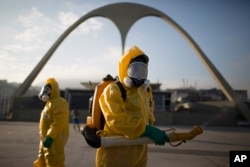 FILE - Health workers spray insecticide to combat the Aedes aegypti mosquito that transmits the Zika virus in Rio de Janeiro, Brazil, Jan. 26, 2016.
