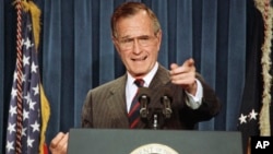 FILE - President George H.W. Bush acknowledges a reporter during a news conference at the White House, Dec. 5, 1991.