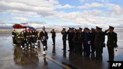 FILE - A picture released on November 30, 2015, by the Turkish army press office shows Turkish soldiers walking by officials of the Russian army as they carry the coffin of the pilot of a Russian jet downed by a Turkish warplane.