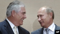 Russian Prime Minister Vladimir Putin, right, and Rex Tillerson, ExxonMobil's chief executive smile during a signing ceremony in the Black Sea resort of Sochi, Russia, Tuesday, Aug. 30, 2011