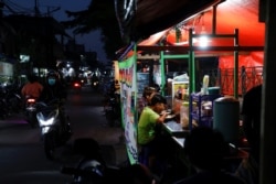 Orang-orang makan malam di tenda jajanan kaki lima saat pelonggaran PPKM di tengah pandemi COVID-19, di Jakarta, 28 Juli 2021. (Foto: REUTERS/Willy Kurniawan)