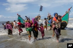 Rohingya Muslims walk to the shore after arriving on a boat from Myanmar to Bangladesh in Shah Porir Dwip, Bangladesh, Sept. 14, 2017.