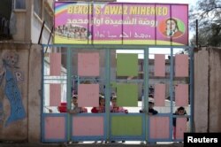 Kurdish children look through a gate at a pre-school in Qamishli, Syria, March 6, 2019. (REUTERS/Issam Abdallah)