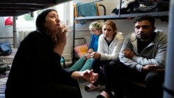 Boshra al-Moallem, second left, sits in a room with her two sisters and brother-in-law at a refugee center in Bialystok, Poland, Sept. 29, 2021.