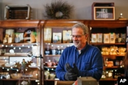 John Winnenberg, a local activist and proprietor of Winding Road Marketplace, a hub for selling the wares of local businesses, stands in his store, Thursday, Dec. 14, 2017, in Shawnee, Ohio. Communities across Appalachia are turning increasingly to the re