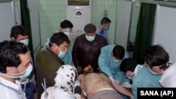 In this Tuesday March 19, 2013 file photo released by the Syrian official news agency SANA, a Syrian victim who suffered an alleged chemical attack at Khan al-Assal village according to SANA, receives treatment by doctors, at a hospital in Aleppo, Syria.