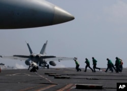 A U.S. Navy F-18 fighter jet takes off from the deck of the USS Carl Vinson (CVN 70) aircraft carrier following a routine patrol off the disputed South China Sea, March 3, 2017.