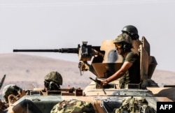 Turkish soldiers sit on a tank driving to Syria from the Turkish Syrian border city of Karkamis in the southern region of Gaziantep, Aug. 27, 2016.