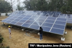 Solar panels are washed at a solar mini-grid installation in Kamlapur, in the Indian state of Uttar Pradesh, Jan. 9, 2018.