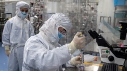 This file photo taken on April 29, 2020 shows an engineer taking samples of monkey kidney cells as he make tests on an experimental vaccine for the COVID-19 coronavirus inside the Cells Culture Room laboratory at the Sinovac Biotech facilities in Beijing. (Photo by NICOLAS ASFOURI / AFP)