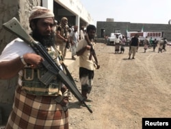 FILE - Yemeni fighters secure a building where UAE Red Crescent distribute aid to displaced people in Al-Mokha, Yemen, March 6, 2018.