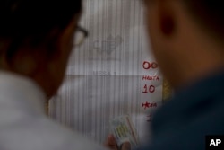 Voters search their voting machine at a voters register outside of a poll station in Caracas, Venezuela, Dec. 10, 2017.