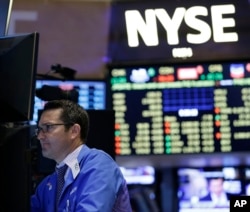FILE - Traders work on the floor at the New York Stock Exchange in New York, July 8, 2015.