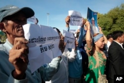 Supporters of the opposition Cambodia National Rescue Party hold a portrait of party leader Kem Sokha and slogans that read: "Free Kem Sokha" during a rally near an appeals court in Phnom Penh, Cambodia, Sept. 26, 2017.
