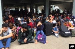 FILE - Myanmar workers wait before leaving Thailand at Mae Sot Immigration office in Tak province Thailand, July 3, 2017.