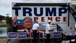 Campaign volunteers prepare signs before a speach by Republican presidential candidate Donald Trump at a campaign rally in Tampa, Florida, Aug. 24, 2016.