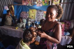 Mary Sanyu, a hairdresser, poses for a photograph in her salon at Konyo Konyo market in Juba, South Sudan on April 15, 2016. (VOA/J. Patinkin)