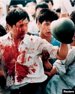 FILE - A blood-covered protester holds a Chinese soldier's helmet following violent clashes with military forces during the 1989 pro-democracy demonstrations in Beijing's Tiananmen Square in this June 4, 1989 photo.