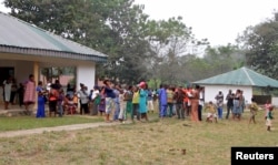 A still image taken from a video shot Dec. 9, 2017, shows Cameroonian refugees standing outside a center in Agbokim Waterfalls village, which is near the Cameroon-Nigeria border.
