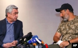 FILE - Serzh Sargsyan, left, speaks with protest leader Nikol Pashinyan during their meeting in Yerevan, Armenia, April 22, 2018.