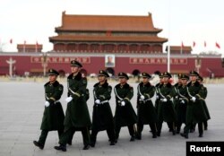 FILE - Paramilitary police walk in formation across Tiananmen Square as the sessions of the National People's Congress are taking place in the nearby Great Hall of the People in Beijing, China, March 6, 2017.