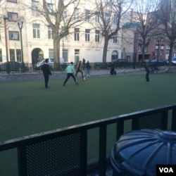 Refugees play football Nov. 23, 2015, near a Brussels camp. The soldiers and tanks guarding the city were not in the neighborhood. (Heather Murdock/VOA)