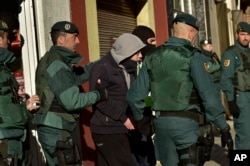 FILE - A unidentified Moroccan leaves a tea shop detained by the Spanish Civil Guard in Pamplona, northern Spain, Dec.1, 2015. Spanish authorities alleged the man was a member of a cell that recruited fighters for the Islamic State group in Syria.