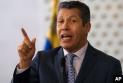 Henri Falcon, a former governor and former aide to the late President Hugo Chavez, speaks to the press after signing a document that states electoral guarantees for the upcoming presidential election at the National Electoral Council in Caracas, Venezuela