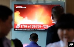 FILE - People watch a TV news program showing a file image of a missile launch conducted by North Korea, at the Seoul Railway Station in Seoul, South Korea, May 14, 2017.