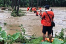 Tim SAR membantu warga menavigasi banjir yang dipicu oleh Badai Tropis Kompasu di Brooke's Point, provinsi Palawan, Filipina barat daya, 12 Oktober 2021. (Penjaga Pantai Filipina via AP)