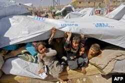 Syrian children, evacuated from rebel-held areas in the Eastern Ghouta, are seen playing at a shelter in the regime-controlled Adra district, on the northeastern outskirts of the capital Damascus, March 20, 2018.