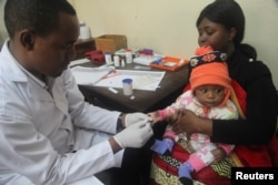 FILE - A doctor tests a child for malaria at a hospital in Arusha, Tanzania, May 11, 2016. The parasitic illness is responsible for about 425,000 deaths annually, most of them children in sub-Saharan Africa.