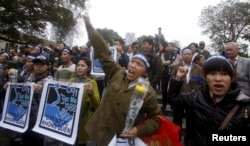 FILE - Anti-China protesters shout "down with invasive China" and hold placards that read "The country will not forget - Johnson South Reef - 14th March, 1988" during a gathering to mark the anniversary of the Spratly Islands clashes between Vietnam and China.