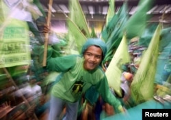 Seorang pendukung Partai Persatuan Pembangunan (PPP) mengikuti pawai kampanye pemilu 2004 di Jakarta, 27 Maret 2004.