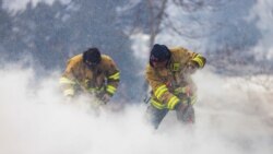 Westminster Fire Department members continue to put out flames from the Marshall Fire in Louisville, Colorado, U.S. December 31, 2021. REUTERS/Alyson McClaran