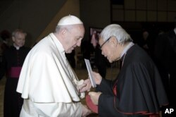 In this Jan. 10, 2018 photo made available the Vatican newspaper L'Osservatore Romano, retired archbishop of Hong Kong Cardinal Joseph Zen hands a letter to Pope Francis at the end of his weekly general audience.