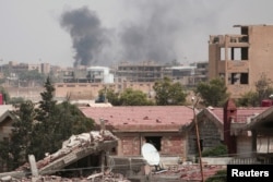 FILE - Smoke rises from the northeastern city of Hasaka, Syria, Aug. 21, 2016.