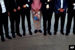 FILE - People hold a photograph of James Foley, a freelance journalist killed by the IS group, during a memorial service in Irbil, 350 kilometers (220 miles) north of Baghdad, Iraq, Aug. 24, 2014.