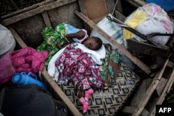 Internally displaced Congolese children sleep in a boat on the shore line of Lake Albert on March 05, 2018 in Tchomia.