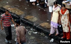 FILE - Two female sex workers stand on a roadside pavement for soliciting customers in a red-light area in Mumbai, July 28, 2007.