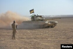 Dust clouds from travelling Iraqi army vehicles are seen during an operation to attack Islamic State militants in Mosul, Iraq, Oct. 21, 2016.