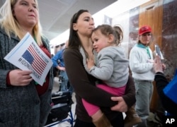 Sarah Myriam of New Jersey holds her daughter Aliyah, 2, as they join activists opposed to vaccinations outside a Senate Health, Education, Labor and Pensions Committee hearing on Capitol Hill in Washington, March 5, 2019.