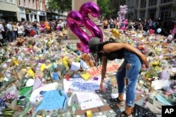 A young woman views of flower tributes for the victims of Monday's explosion at St Ann's square in central Manchester, England, May 25 2017.