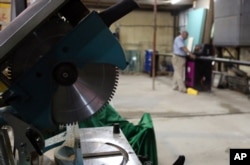 A worker works to sustain a machine at an aluminum factory in Baghdad, Iraq, Aug. 15, 2015.