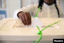 A Kenyan woman casts her vote at a mock polling station during a pre-election exhibition in Nairobi, June 12, 2017.