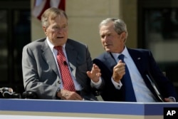 FILE - Former President George W. Bush, right, talks with his father, former President George H.W. Bush, during the dedication of the George W. Bush Presidential Center in Dallas, April 25, 2013. Father and son say they will not be endorsing Donald Trump'