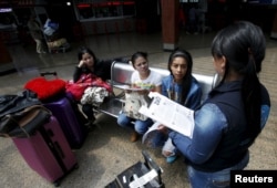 A Colombian health worker gives travellers information on how to prevent the spread of the Zika virus, at the main bus terminal in Bogota, Colombia, Jan. 31, 2016.